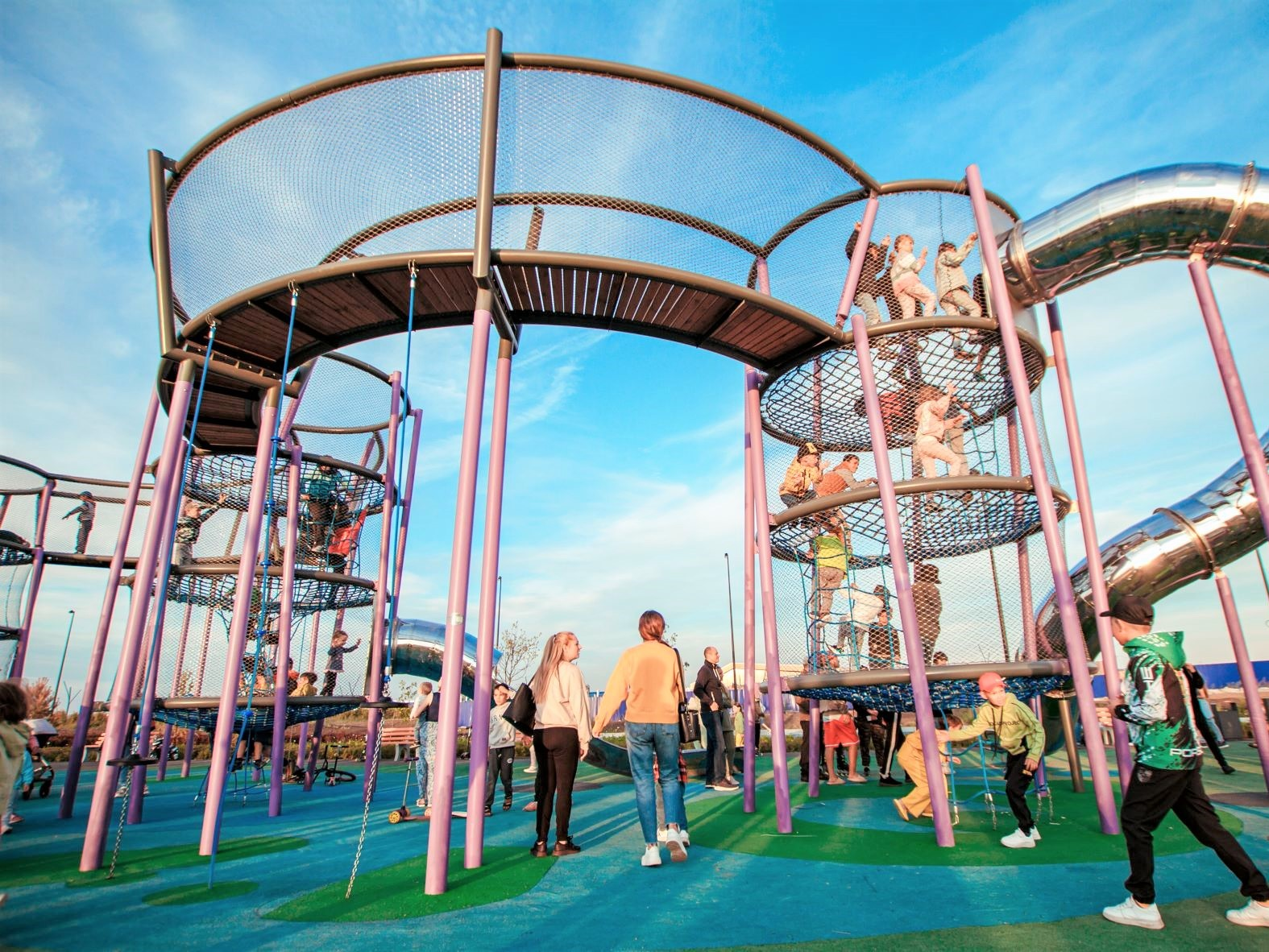 Panoramic full view giant circular multi-layer climbing tower with purple steel frame and twin stainless spiral slides
