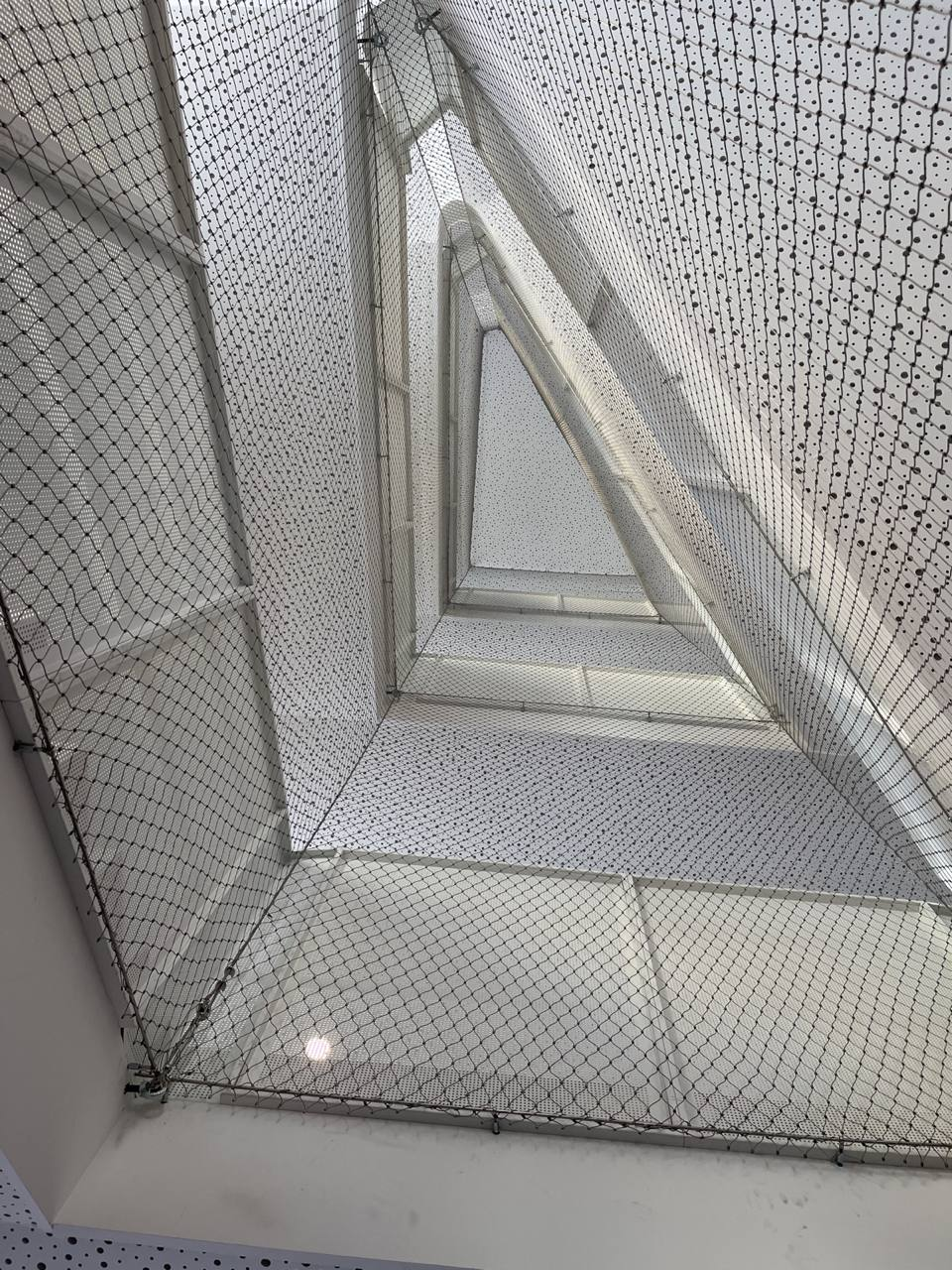 Angled overhead safety cable mesh inside shopping mall atrium