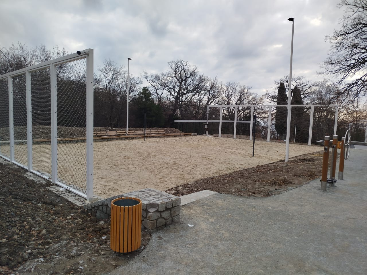Sand volleyball venue surrounded by white powder coated stainless cable mesh fence