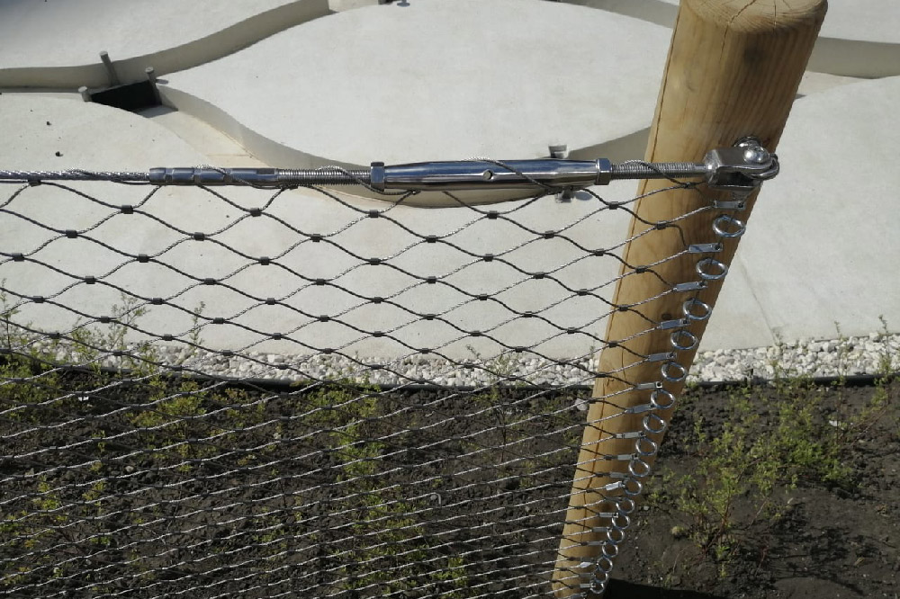 Wood post stainless anchor ring fixed mesh installation close shot