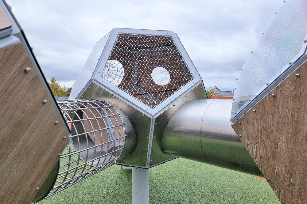 Stainless mesh crawl tunnel connecting two hexagonal play boxes close-up shot