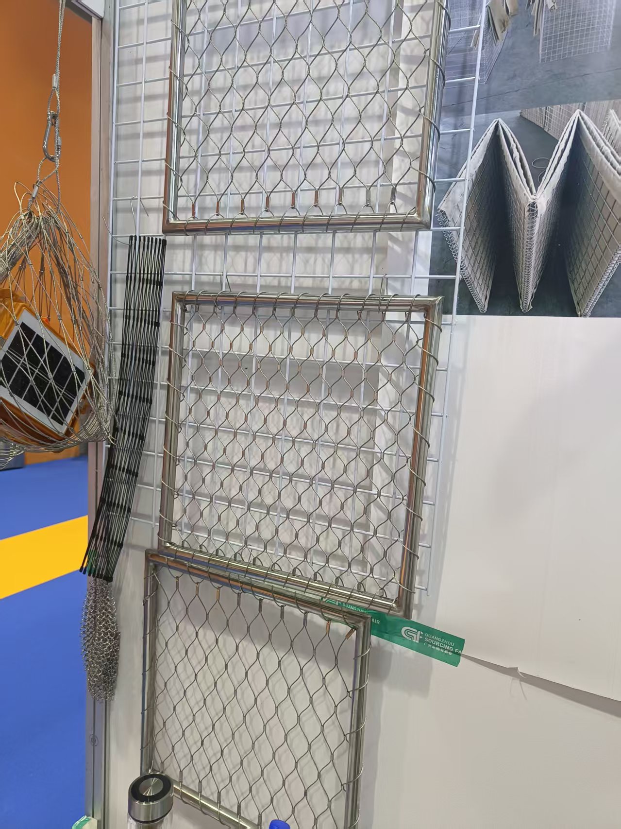 Customers consulting technical parameters of stainless steel rope mesh at exhibition booth
