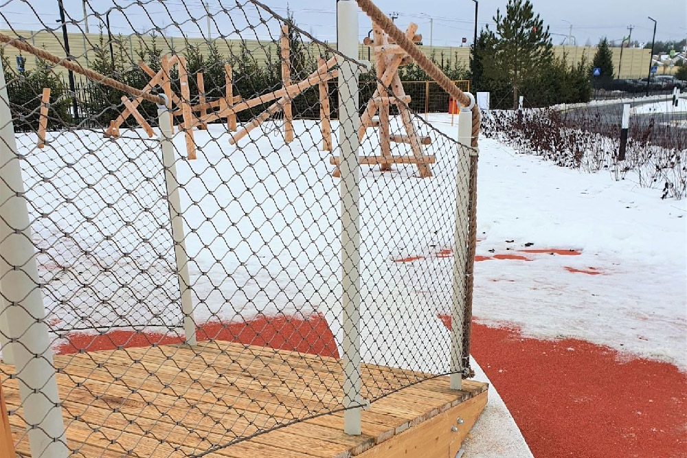 Mesh balustrade around wooden play platform outdoor playground