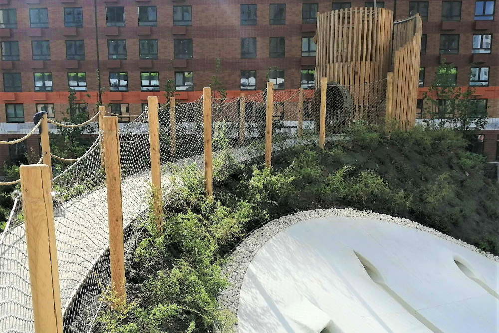 Full panoramic view sloped play mound with solid timber posts and stainless cable mesh balustrade, residential compound natural play area