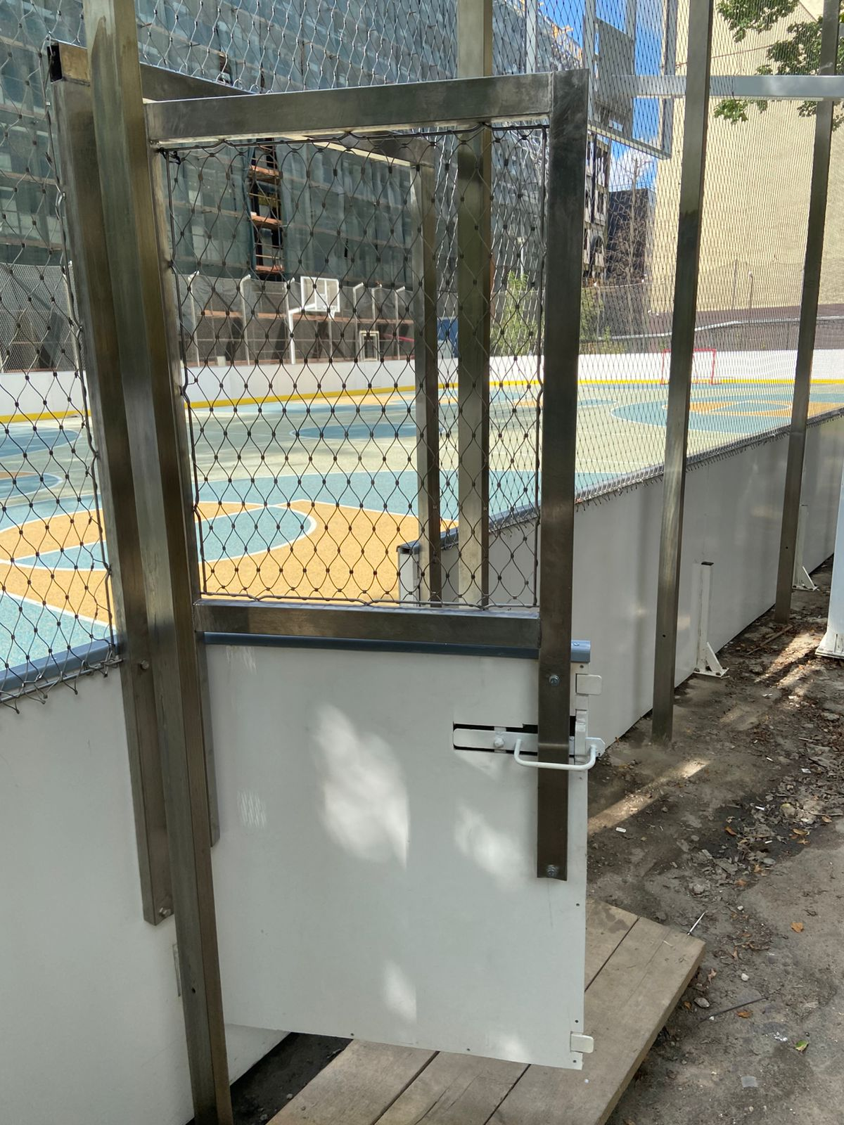 Custom stainless steel gate integrated into sport court rope mesh fence system