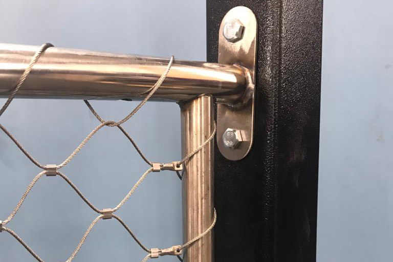 Mesh fixed to polished stainless handrail & black steel bracket close-up